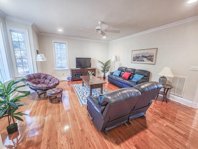 living room with ornamental molding, ceiling fan, and light wood-type flooring