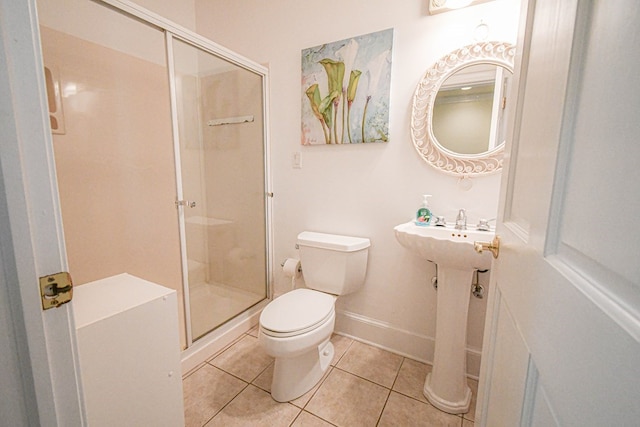 bathroom with tile patterned flooring, sink, a shower with door, and toilet