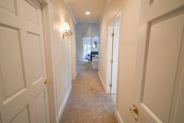 hallway featuring crown molding and light carpet