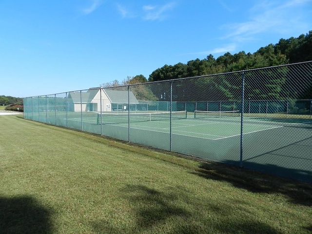 view of tennis court with a yard