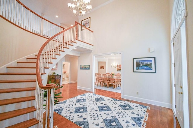 entrance foyer with hardwood / wood-style floors, a high ceiling, and a notable chandelier