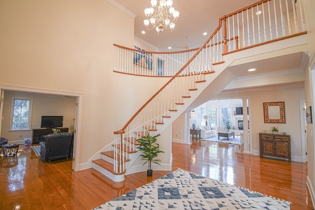 stairway featuring wood-type flooring, a wealth of natural light, and crown molding