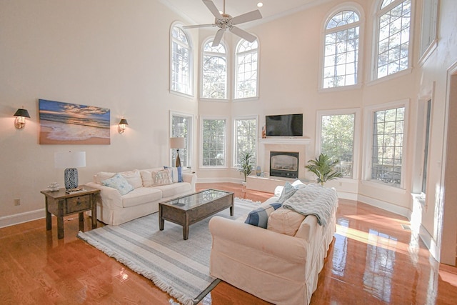 living room featuring ornamental molding, plenty of natural light, ceiling fan, and light hardwood / wood-style flooring