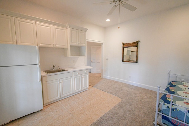 kitchen featuring white refrigerator, sink, white cabinets, and ceiling fan