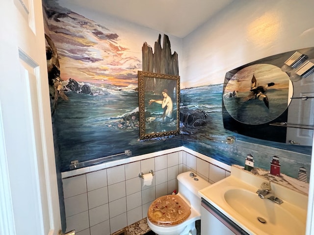 bathroom with vanity, tile walls, and toilet