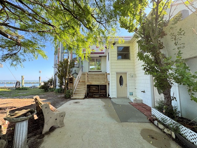 view of front of property with a water view and a patio