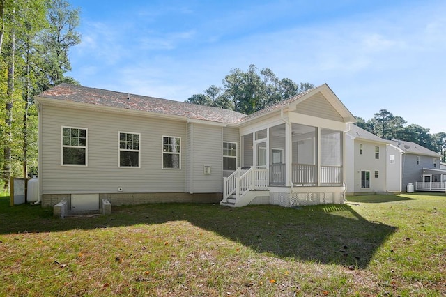 back of property with a lawn and a sunroom