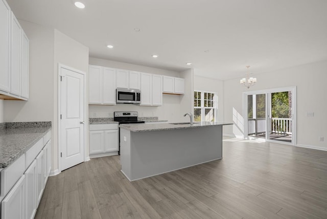 kitchen featuring sink, an island with sink, light stone counters, white cabinetry, and stainless steel appliances