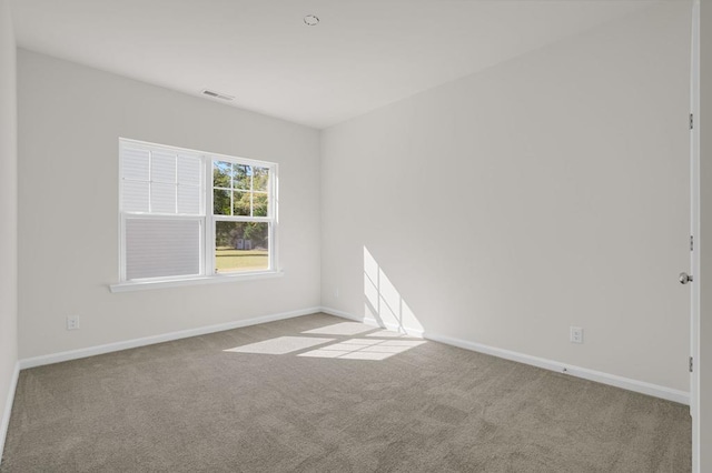 spare room featuring light colored carpet