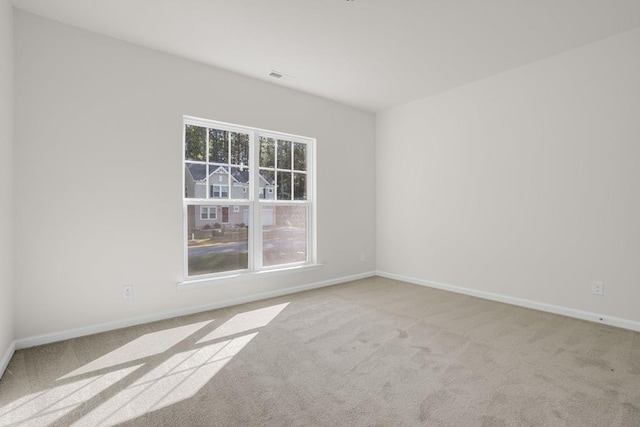 spare room featuring light colored carpet