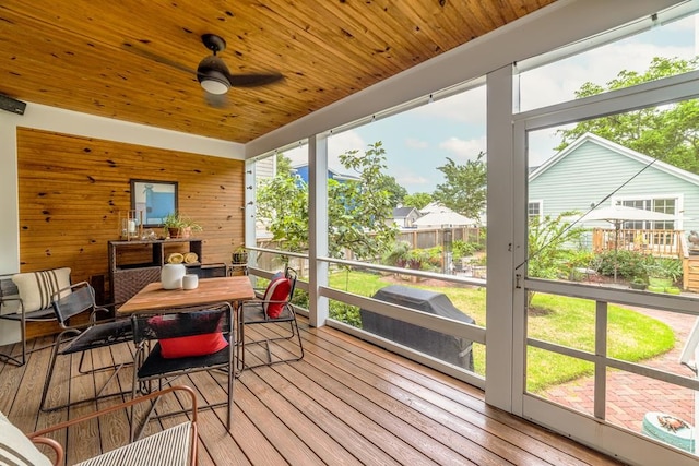 sunroom featuring a healthy amount of sunlight, wooden ceiling, and a ceiling fan