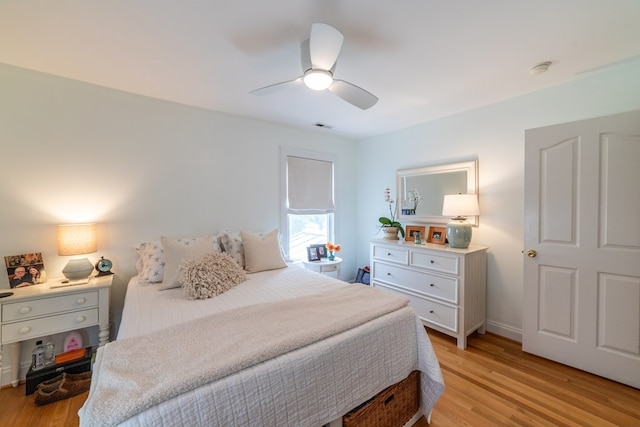 bedroom featuring a ceiling fan, baseboards, visible vents, and light wood finished floors