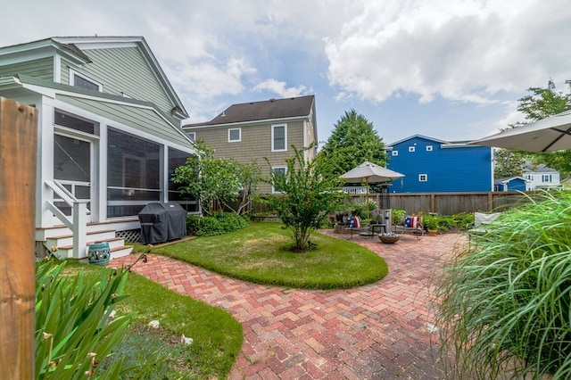 view of yard featuring a sunroom, fence, and a patio