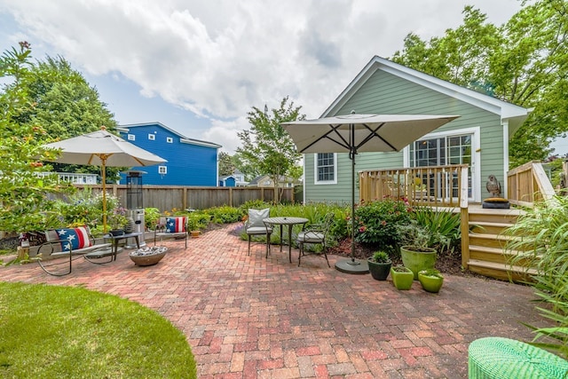 view of patio / terrace with a fire pit, fence, and a wooden deck