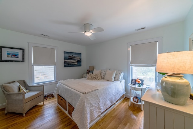 bedroom featuring light wood-type flooring, visible vents, ceiling fan, and baseboards