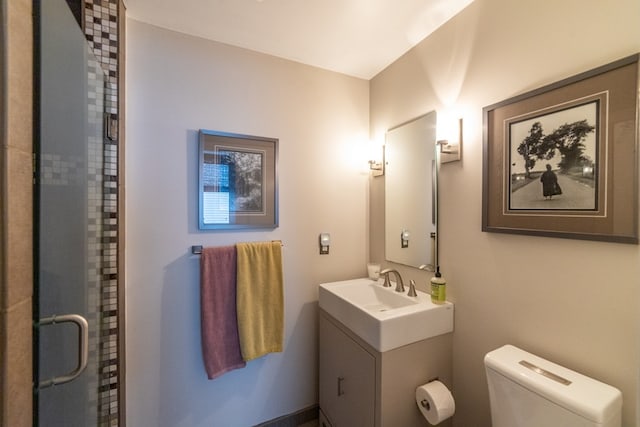 full bath featuring toilet, a stall shower, and vanity