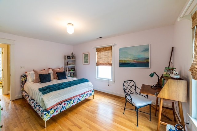 bedroom with light wood finished floors and baseboards