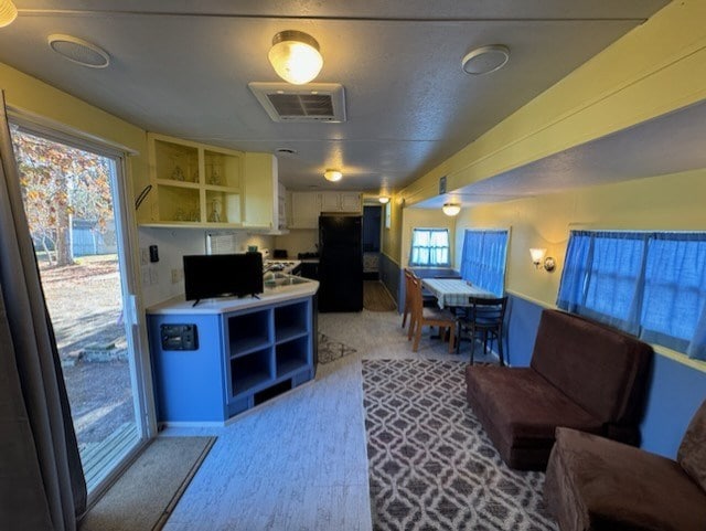 kitchen with white cabinets and black fridge