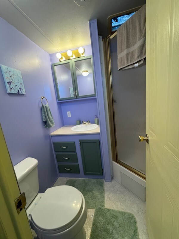 full bathroom with shower / bath combination with glass door, vanity, and toilet