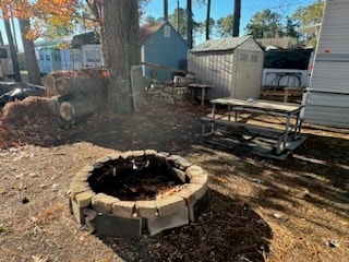 view of yard with a fire pit and a storage unit