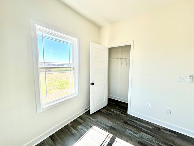 37734 Blue Crab Cir, Painter, VA 23420 - unfurnished bedroom featuring baseboards, dark wood-style floors, and a closet