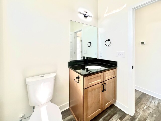 37734 Blue Crab Cir, Painter, VA 23420 - half bathroom featuring toilet, vanity, baseboards, and wood finished floors