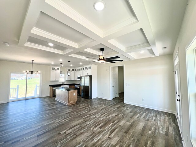 37734 Blue Crab Cir, Painter, VA 23420 - unfurnished living room featuring baseboards, a sink, ceiling fan with notable chandelier, dark wood-style floors, and coffered ceiling