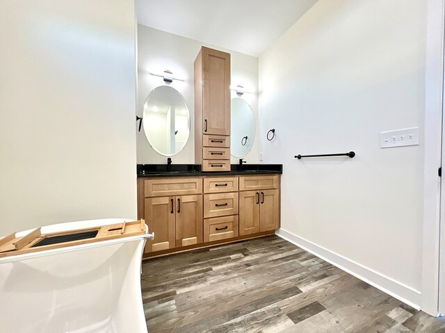 37734 Blue Crab Cir, Painter, VA 23420 - bathroom featuring baseboards, wood finished floors, double vanity, and a sink
