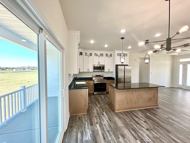 37734 Blue Crab Cir, Painter, VA 23420 - kitchen featuring a kitchen island, appliances with stainless steel finishes, dark countertops, white cabinets, and dark wood-type flooring