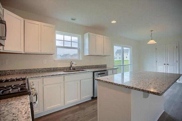 kitchen featuring a kitchen island, appliances with stainless steel finishes, white cabinets, and a sink