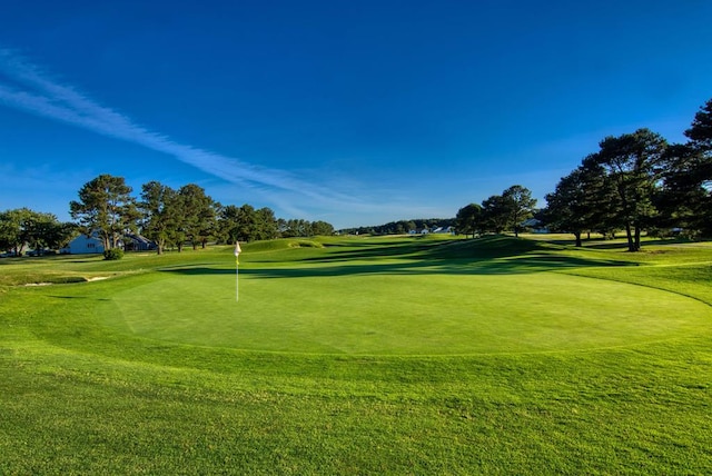 surrounding community featuring view of golf course and a yard