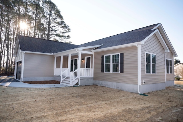 view of front facade featuring covered porch and a shingled roof