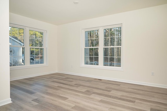 spare room with light wood-type flooring and baseboards