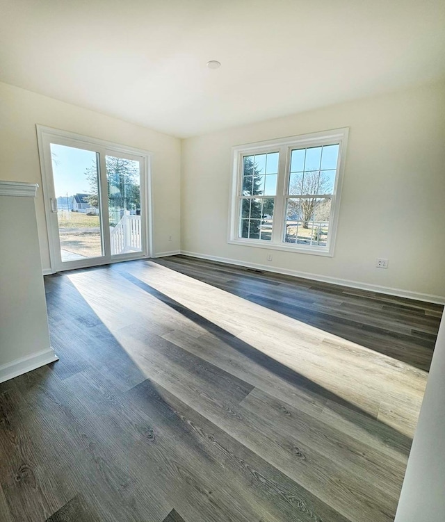 empty room featuring dark wood finished floors and baseboards