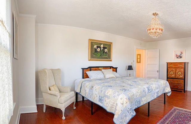 bedroom with dark hardwood / wood-style flooring, ornamental molding, a textured ceiling, and an inviting chandelier