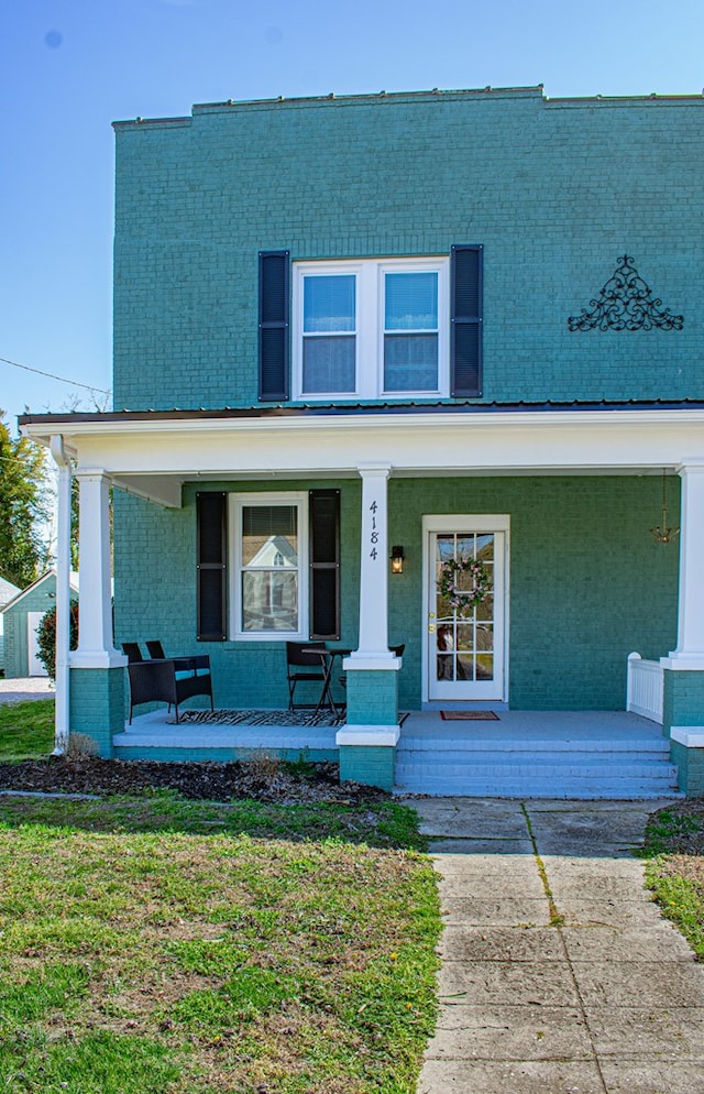 view of front of property with covered porch and a front lawn