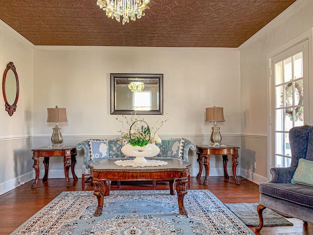 living area featuring a chandelier, dark hardwood / wood-style flooring, and crown molding