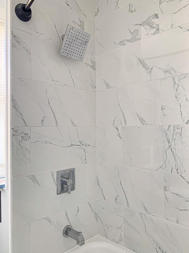 room details with tiled shower / bath combo