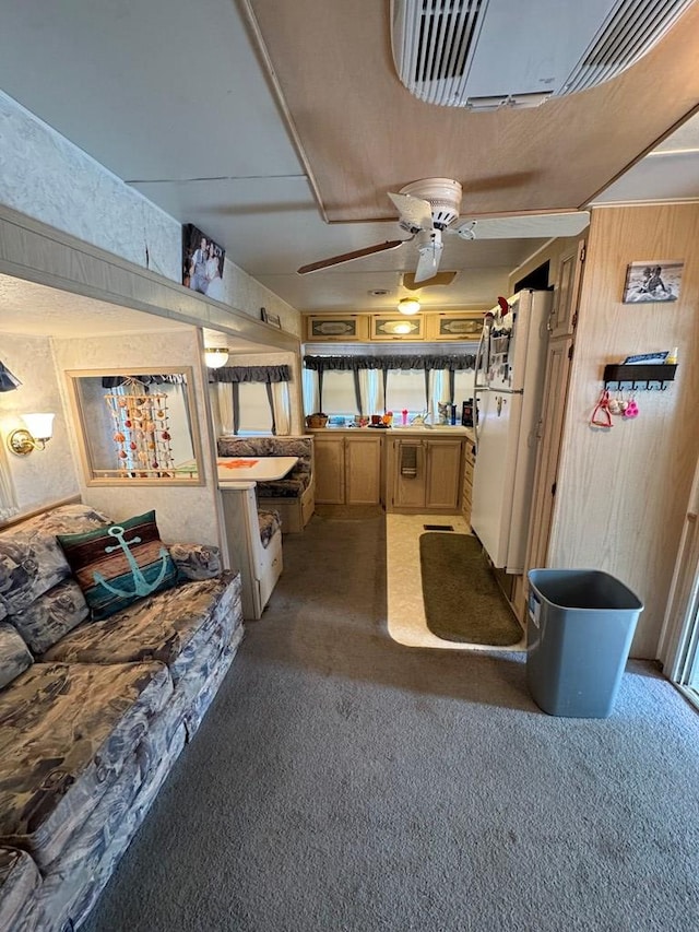 interior space with carpet flooring, ceiling fan, and white refrigerator