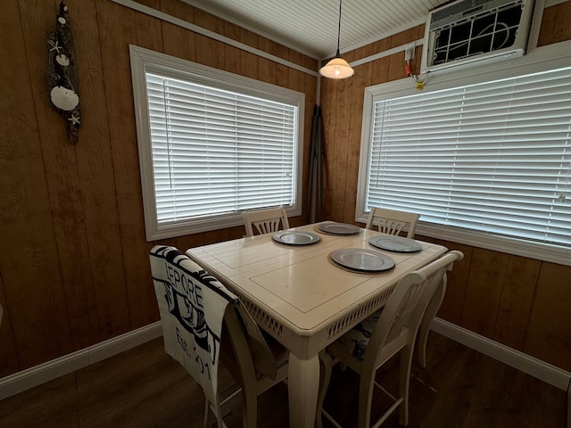 dining area with an AC wall unit, wood walls, and dark hardwood / wood-style floors