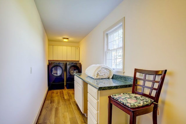 kitchen featuring washing machine and dryer, light hardwood / wood-style flooring, and white cabinets