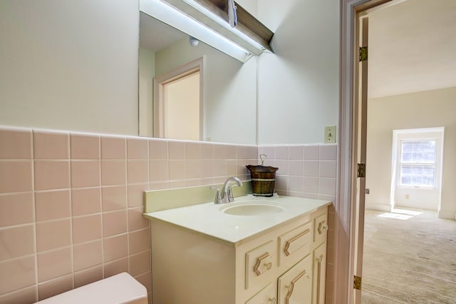 bathroom with vanity, tile walls, and toilet