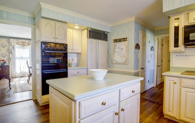 kitchen featuring dark hardwood / wood-style flooring, a kitchen island, ornamental molding, and black appliances