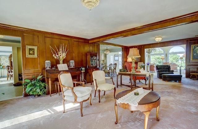 interior space featuring wood walls, light colored carpet, ornamental molding, and an inviting chandelier