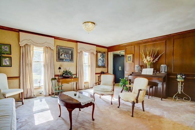 sitting room with wooden walls, light colored carpet, and ornamental molding