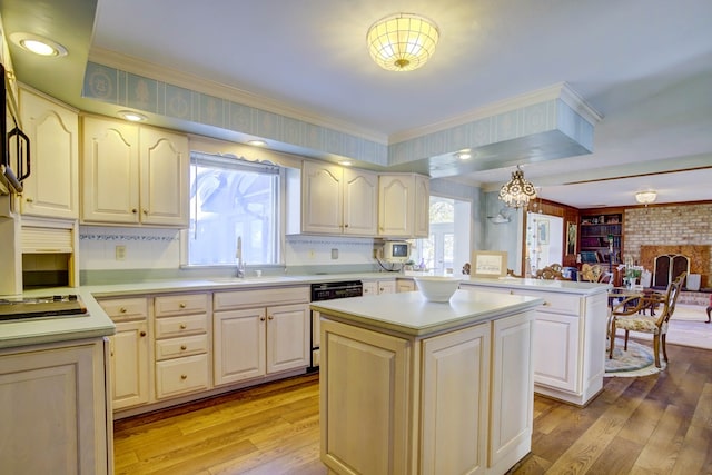 kitchen with a center island, sink, a notable chandelier, light hardwood / wood-style floors, and kitchen peninsula