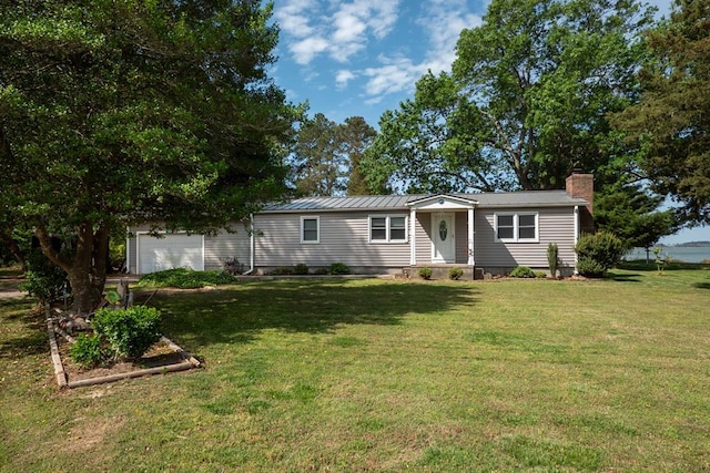 31510 Sunset Dr, Painter, VA 23420 - view of front of home featuring a garage, a front lawn, a chimney, and metal roof