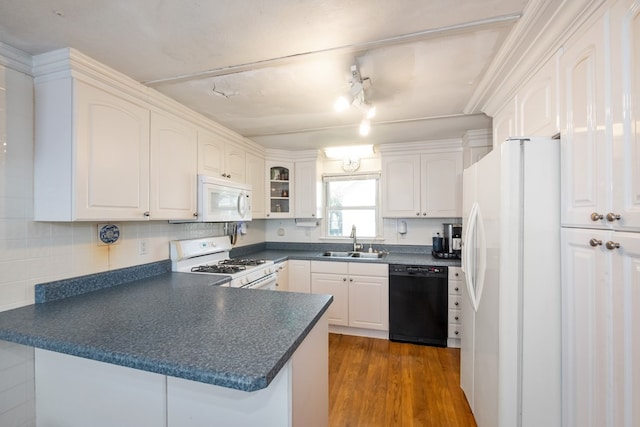 31510 Sunset Dr, Painter, VA 23420 - kitchen featuring dark countertops, a sink, white appliances, a peninsula, and white cabinetry