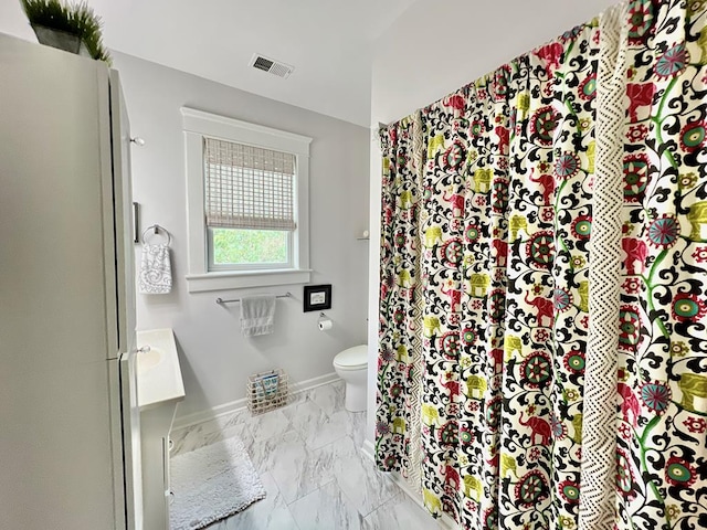 2453 Sand Hill Dr, Cape Charles, VA 23310 - full bath with marble look tiles, toilet, vanity, and baseboards