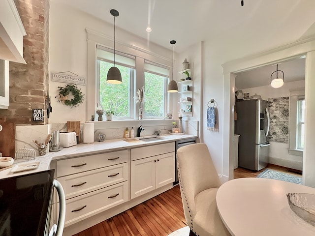 2453 Sand Hill Dr, Cape Charles, VA 23310 - kitchen featuring appliances with stainless steel finishes, light wood-style flooring, a sink, light countertops, and white cabinetry